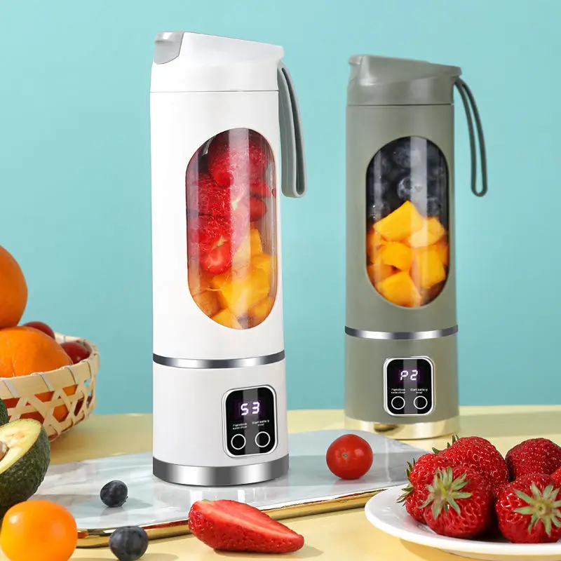Two Tumbla Go blenders, white and green, on a table with fresh fruit